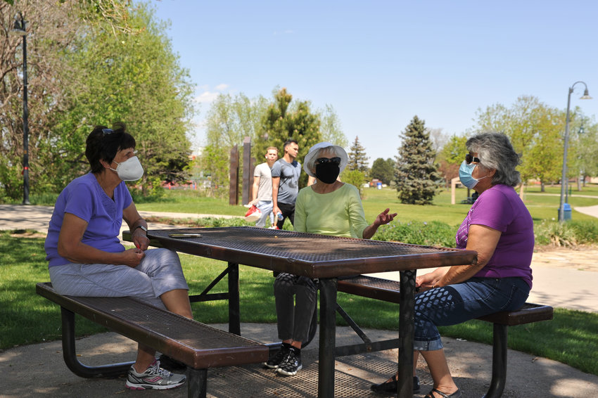 Peggy England of Westminster, center, talks with Pauline Brito, right, of Northglenn, and Pat Gualtier of Thornton, during the lunch hour at E.B. Rains, Jr. Memorial Park in Northglenn May 19.